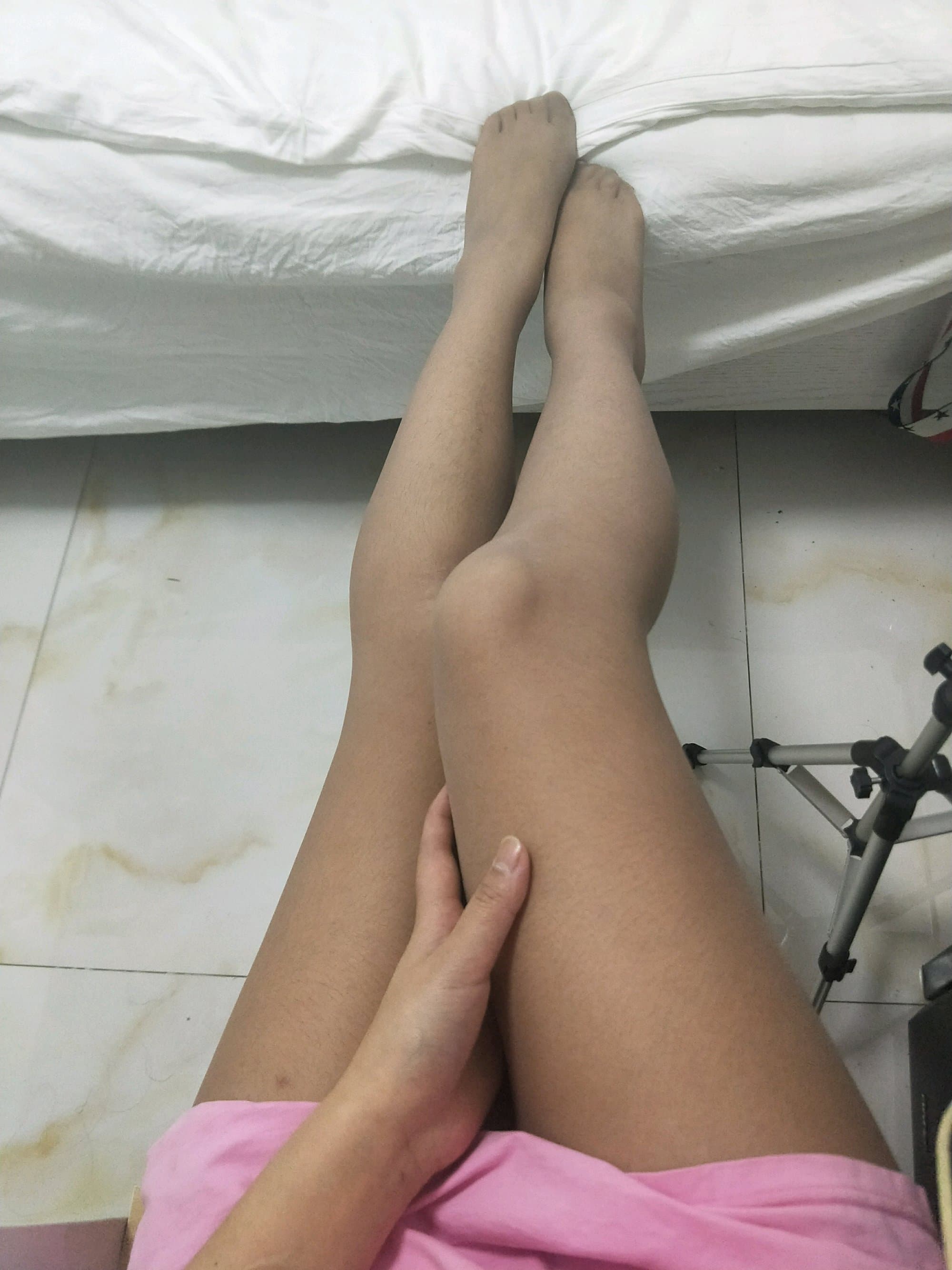 Close portrait of thick, unshaven legs with stocking seams and hair visible beneath sheer fabric