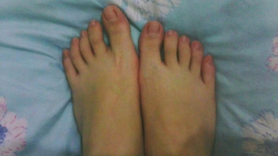 Graceful slender feet posed to highlight high arches and elegant toes, with a soft nylon sheen on the skin.