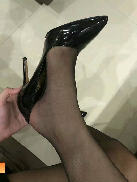 Close-up of warm bare feet slipping from cotton socks, toes curled in gentle, flirtatious posture on soft bedding.