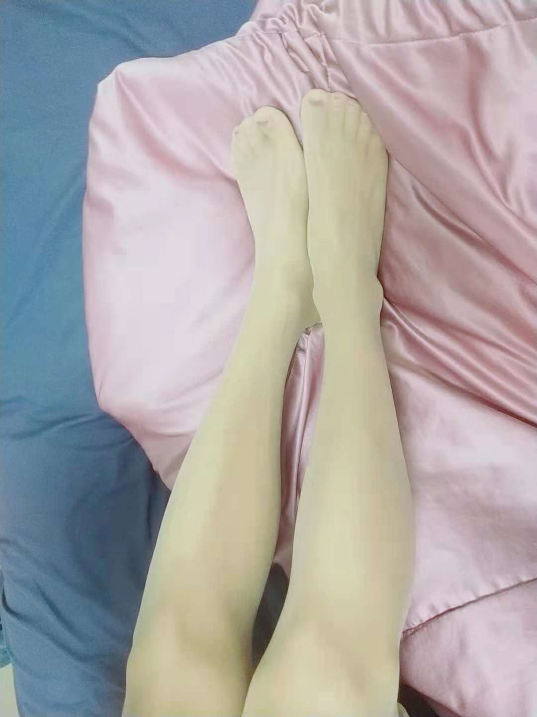 Sheer stockings on a poised foot, toe lines visible through nylon, subtle sheen catching the light and enhancing the arch.