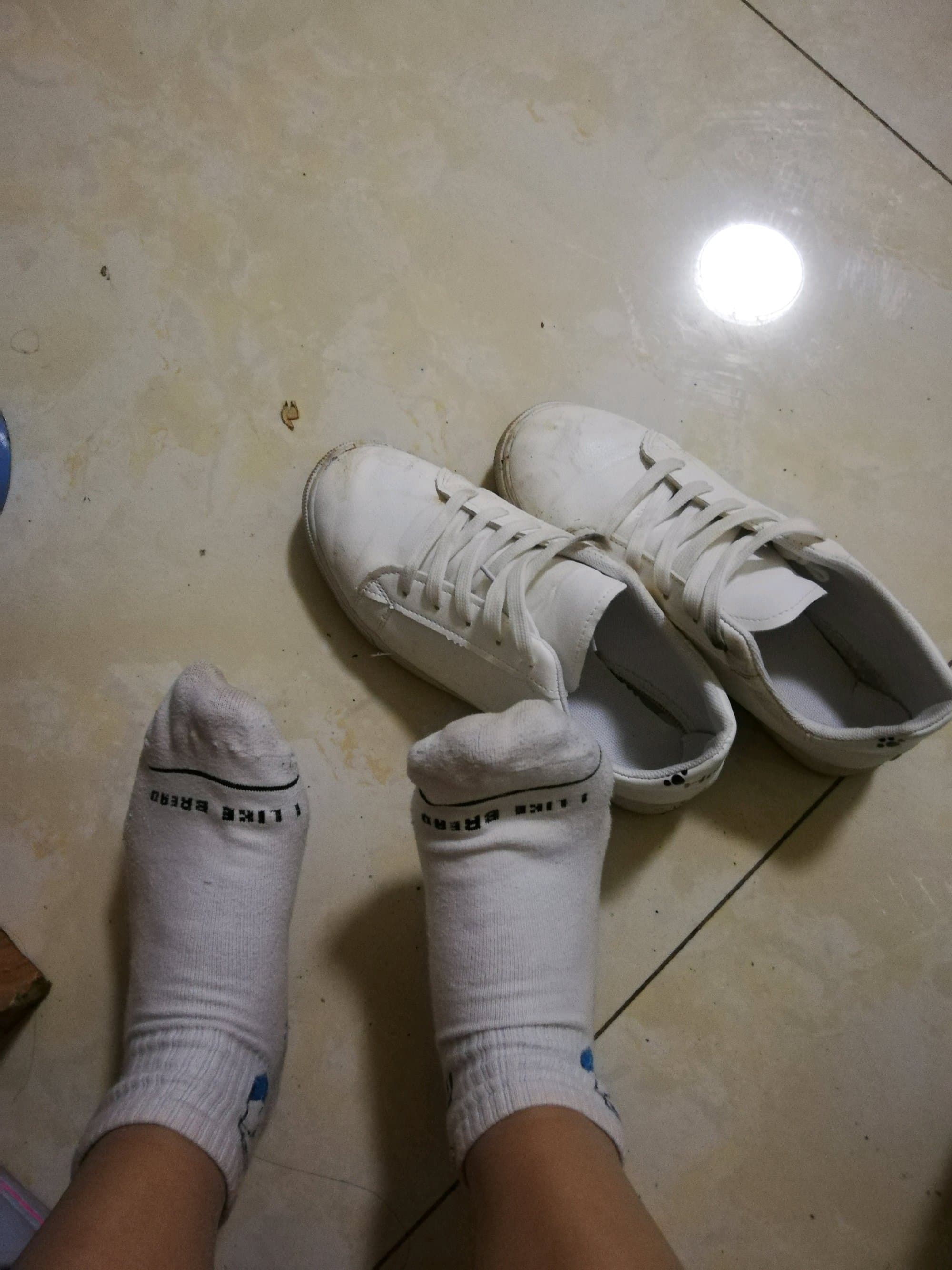 adult feet in tiny white shoes and cotton socks