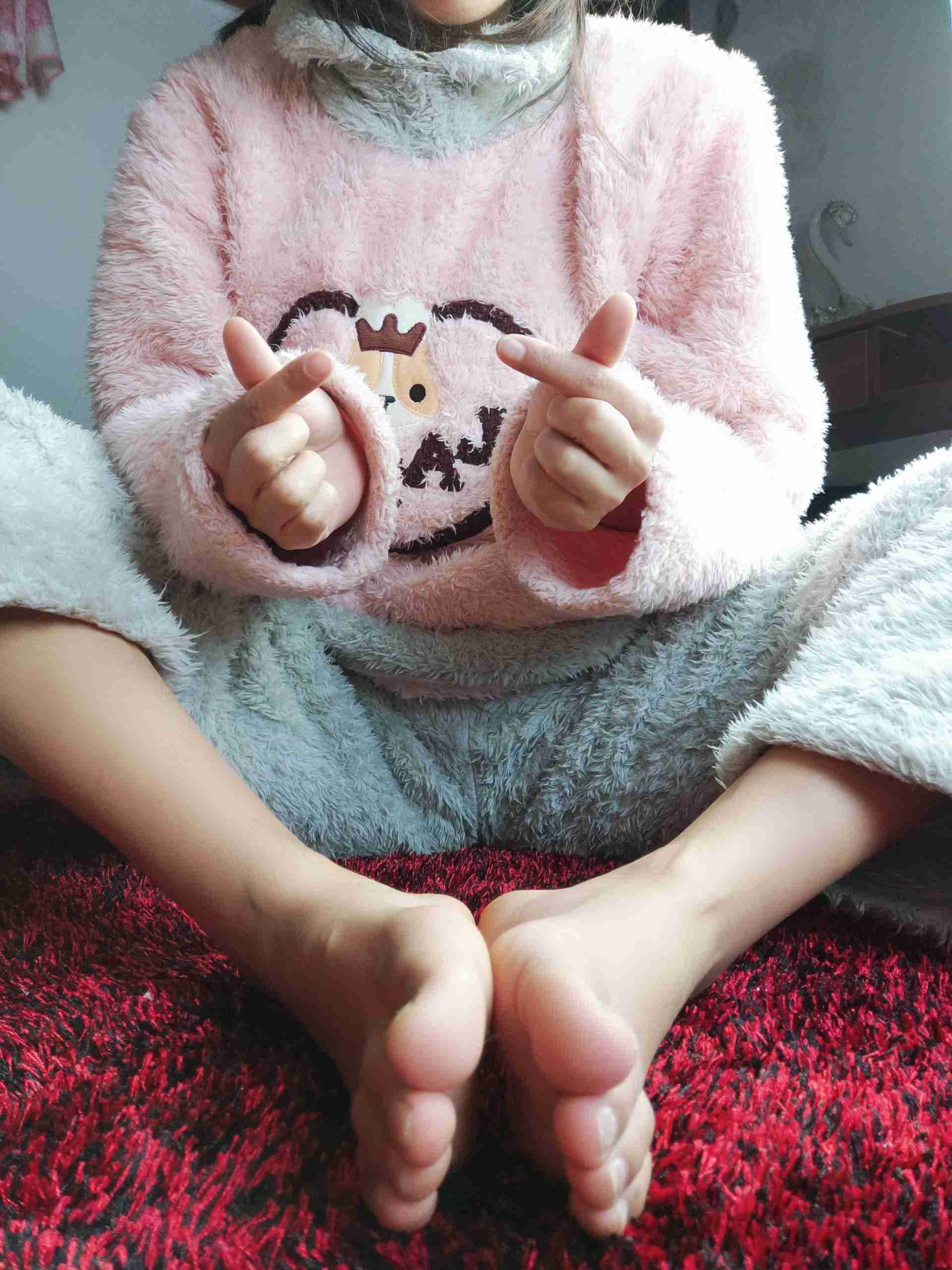 Assorted socks on a pair of feet showing diverse textures from cotton to nylon and playful rolls