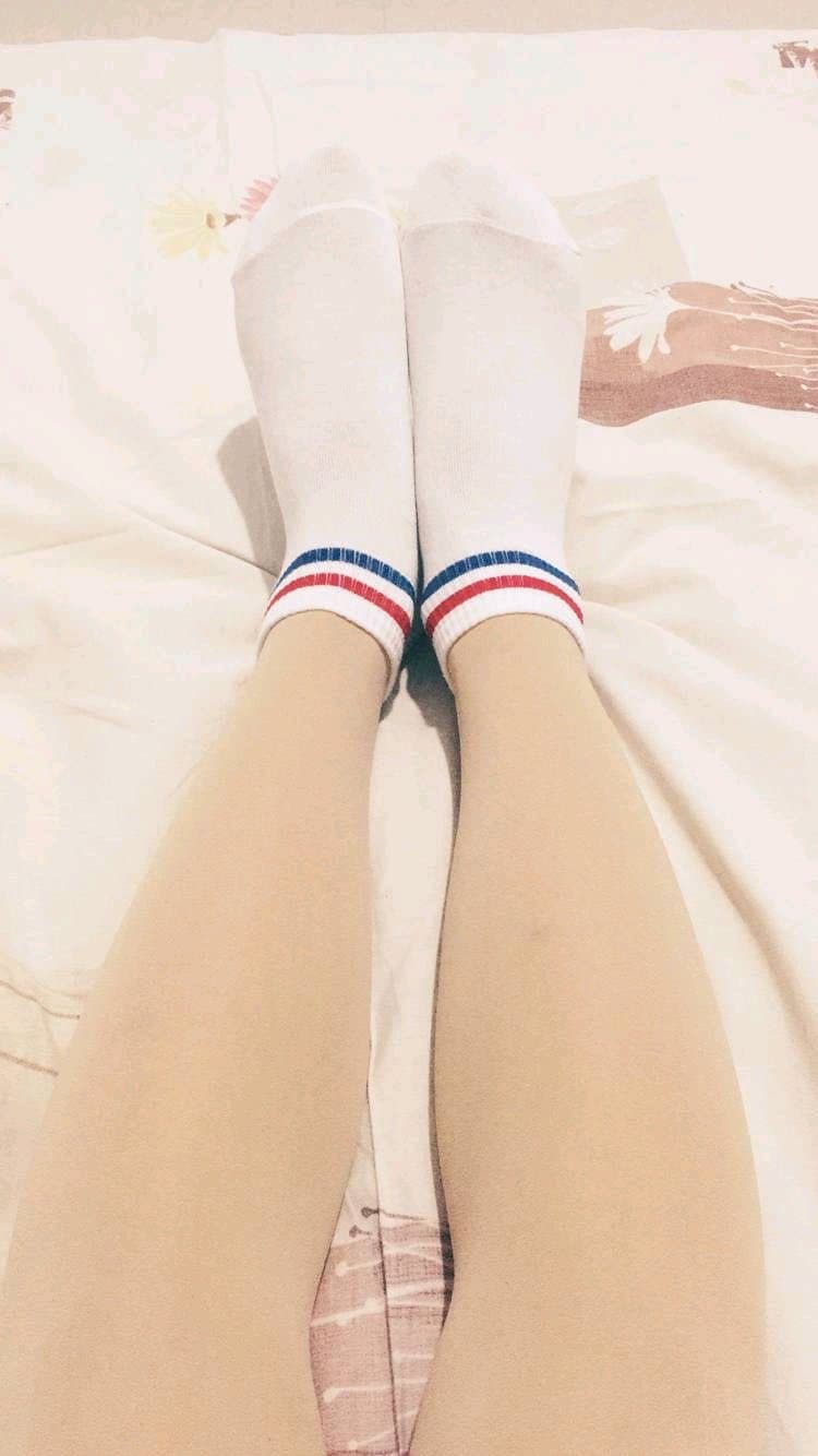 Playful fan admiring a cuffed stockinged foot, toes peeking from fabric edge