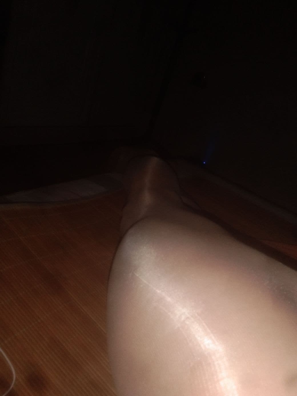 Shiny nylon stockings glistening under soft light, emphasizing heel and arch