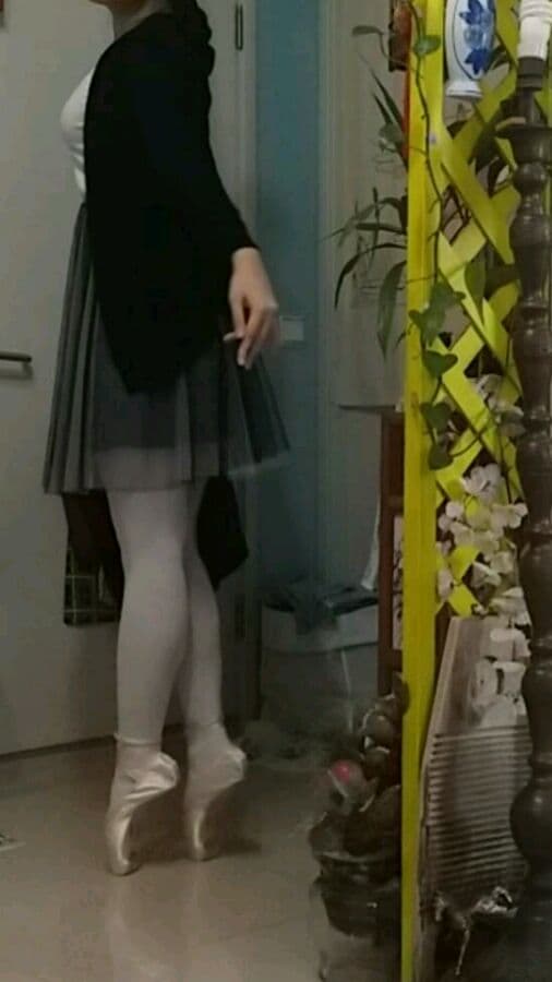 Ballet dancer’s feet in sheer stockings, soft satin ribbons and pointed arch outlines