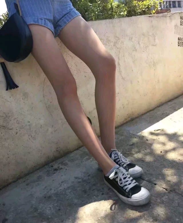 Timid newcomer showing bare feet in soft cotton socks and sheer stockings, legs tucked close, inviting gentle praise