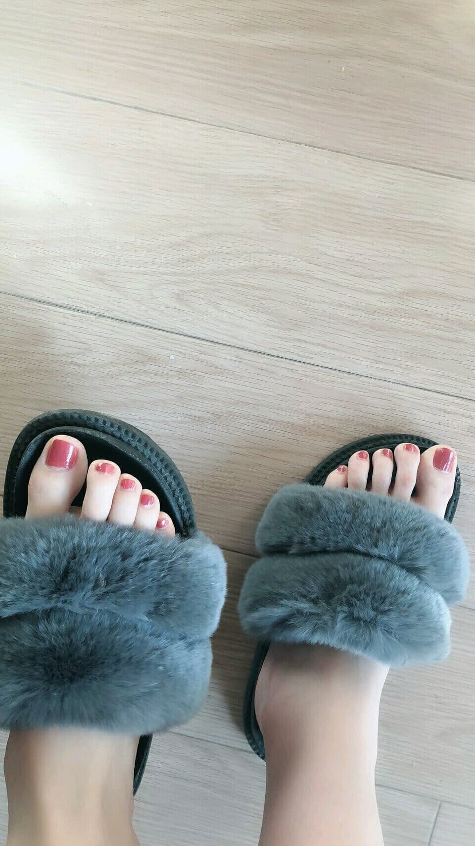 Steaming basin beside a low bed, bare feet gently submerged in warm water, winter light filtering through a curtain.