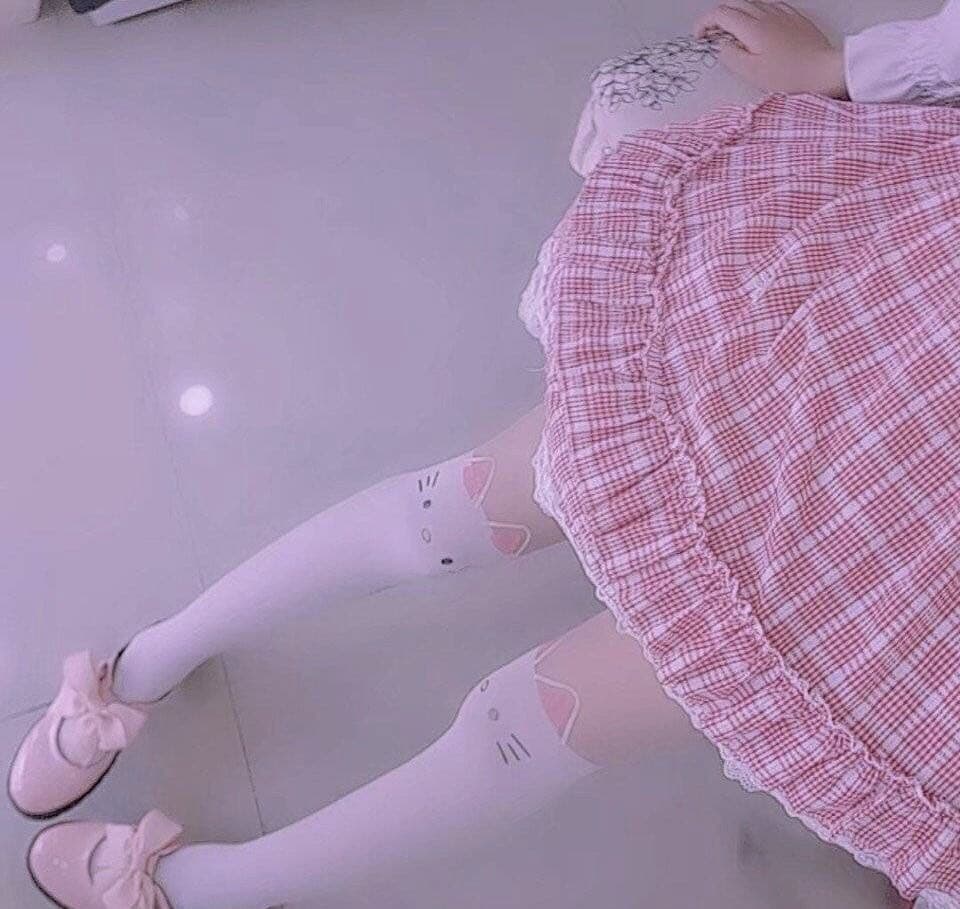 Low light shot of crossed legs in sheer stockings, glow highlighting toes peeking through delicate nylon fabric.