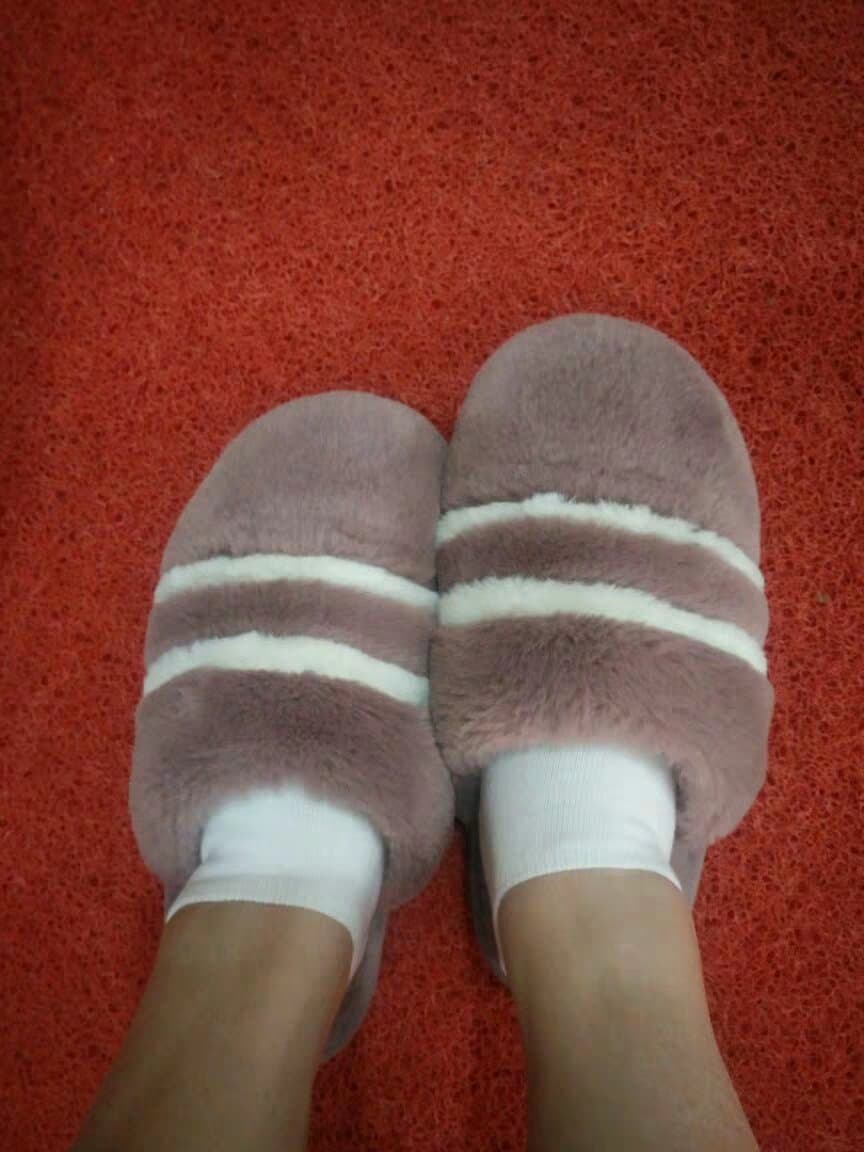Close-up of bare Asian feet resting on couch, toes slightly curled, soft soles catching warm light.
