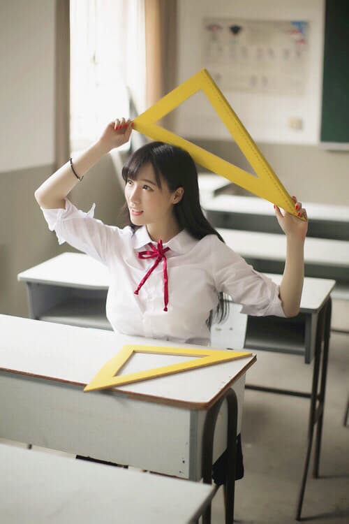 Petite adult student sitting by a window, adjusting sheer stockings, bare toes peeking from fabric