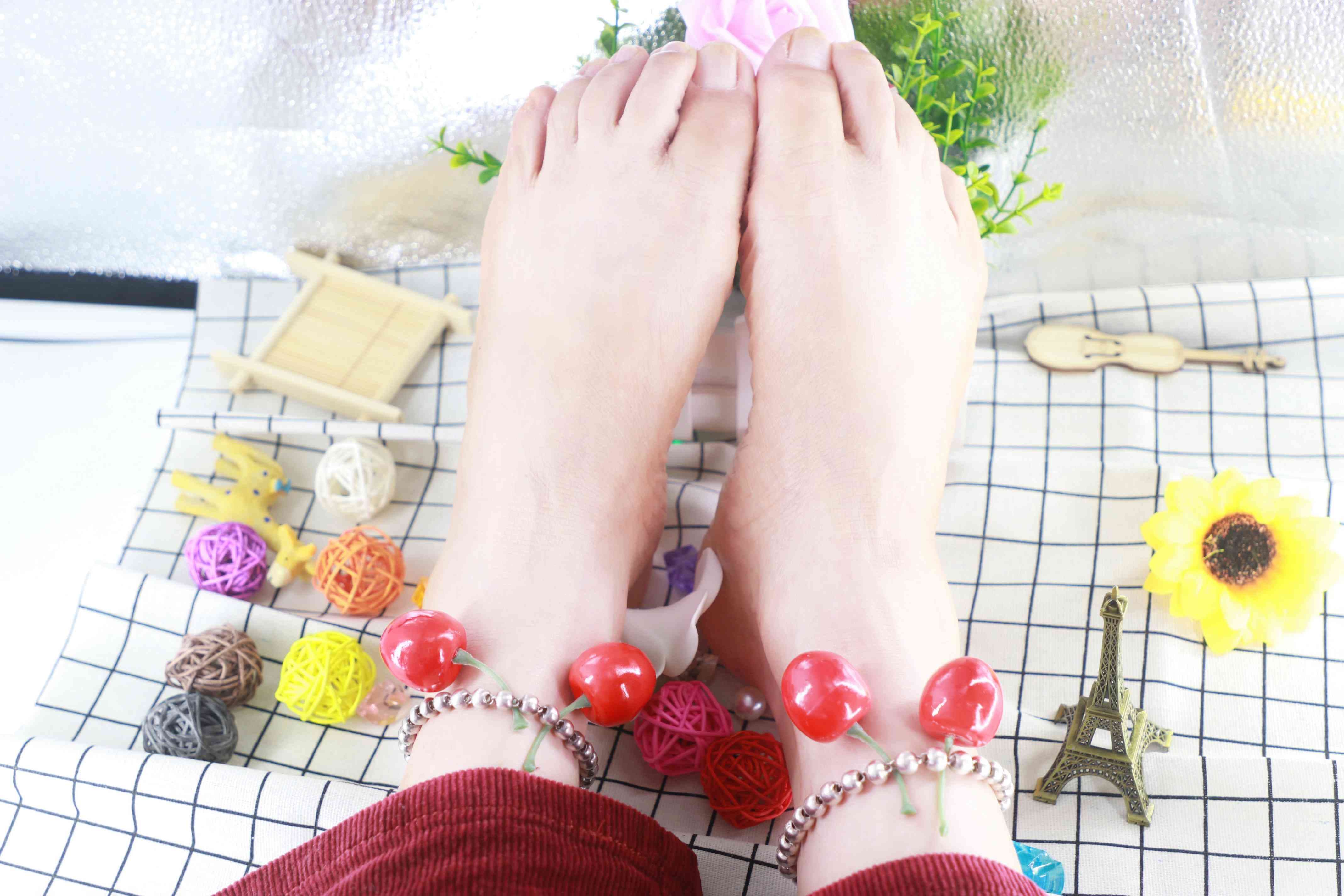 Low-angle shot of a barefoot posed on a bed, arches prominent and toes spread, natural skin tones and faint shadows enhancing sensual detail