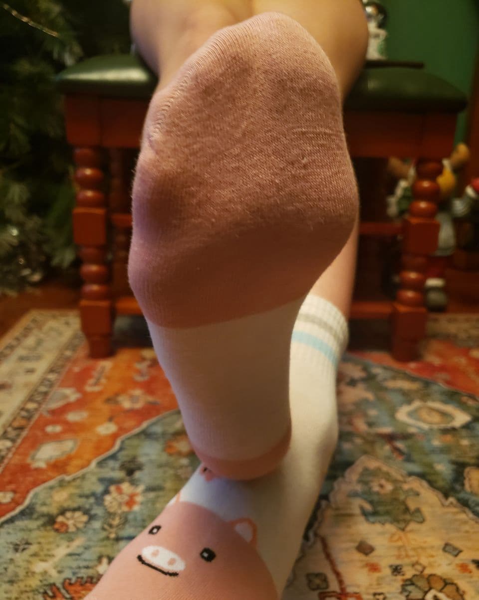 Close-up of worn cotton socks hugging a foot, fabric texture visible and slightly rumpled for a lived-in look