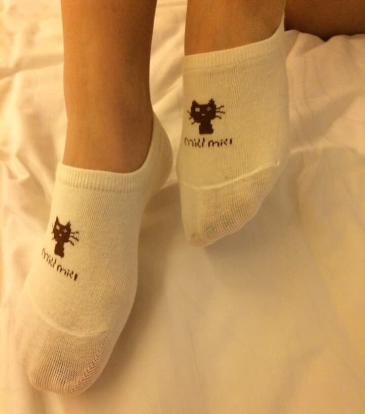 Close-up of bare feet dusted with strawberry-scented powder, pink nylon stockings rolled around ankles, soft light highlighting toes.