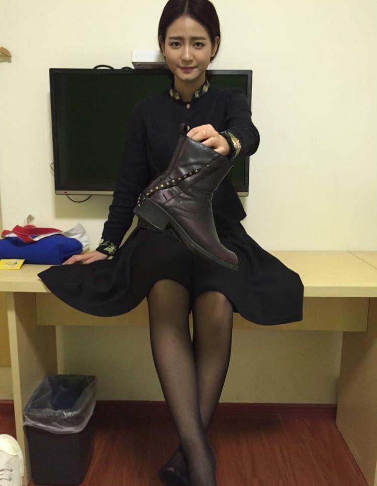 Ankle and calf in sheer stockings with a hand tugging lightly at a cotton sock edge