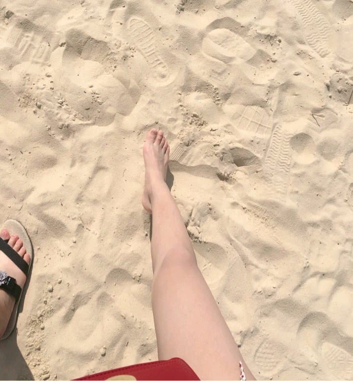 Close shot of a hand cradling a stockinged foot, faint sheen on nylon highlighting curves