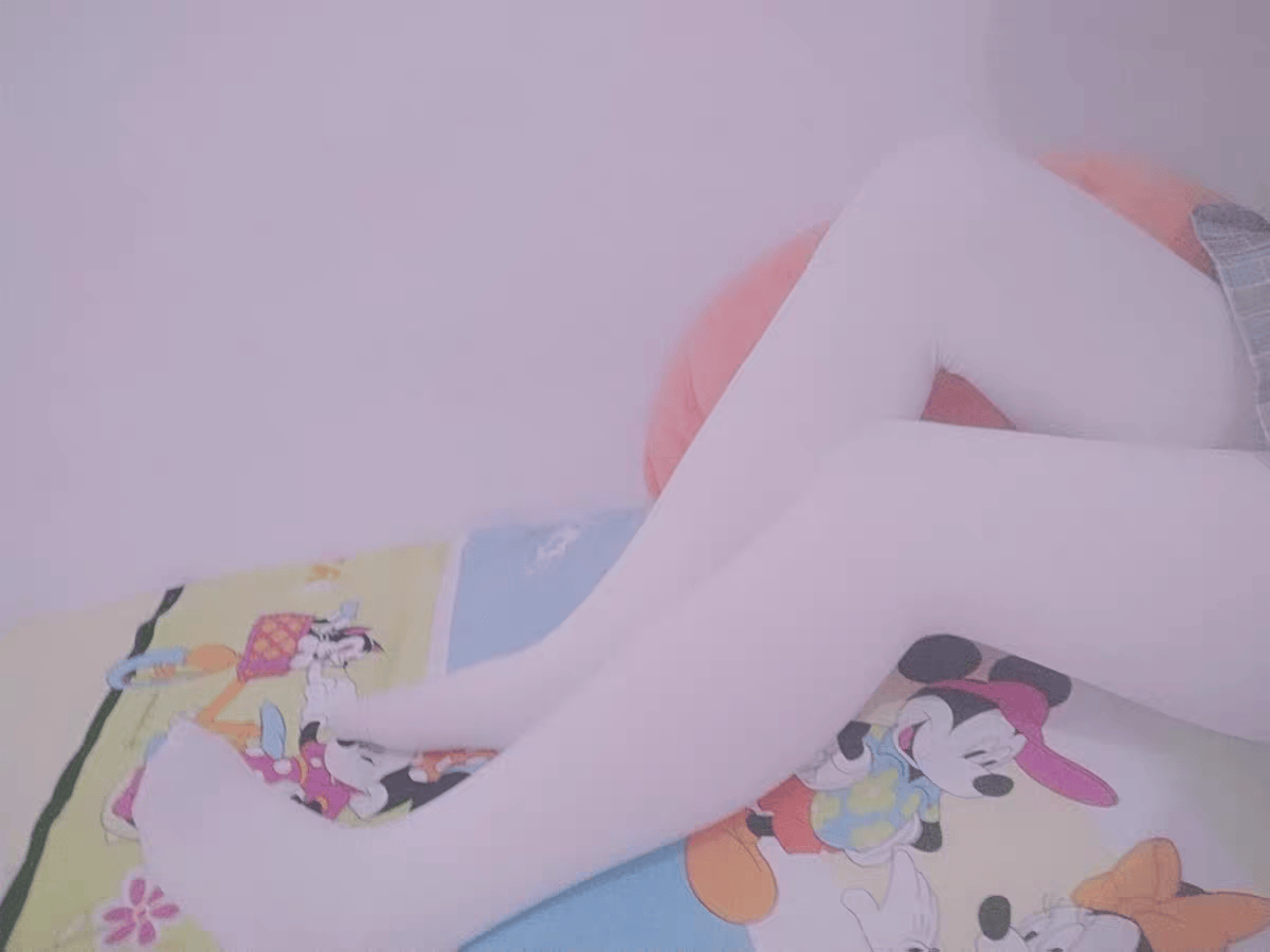 Intimate shot of sheer pantyhose being smoothed over a foot, highlighting silky texture and toe outline.