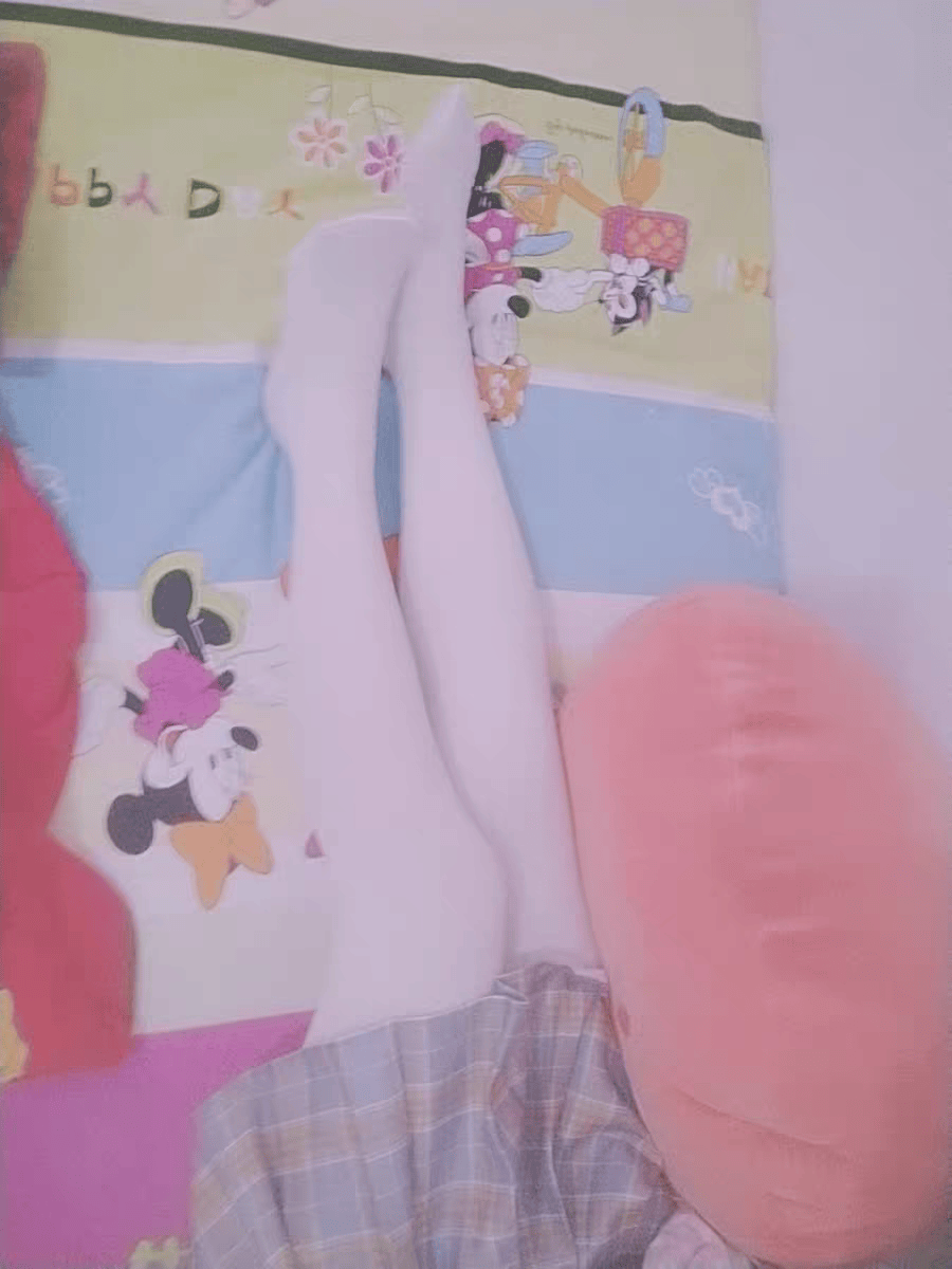 Ankle-length view of glossy pantyhose with fingers adjusting the fabric, light reflecting on the nylon.