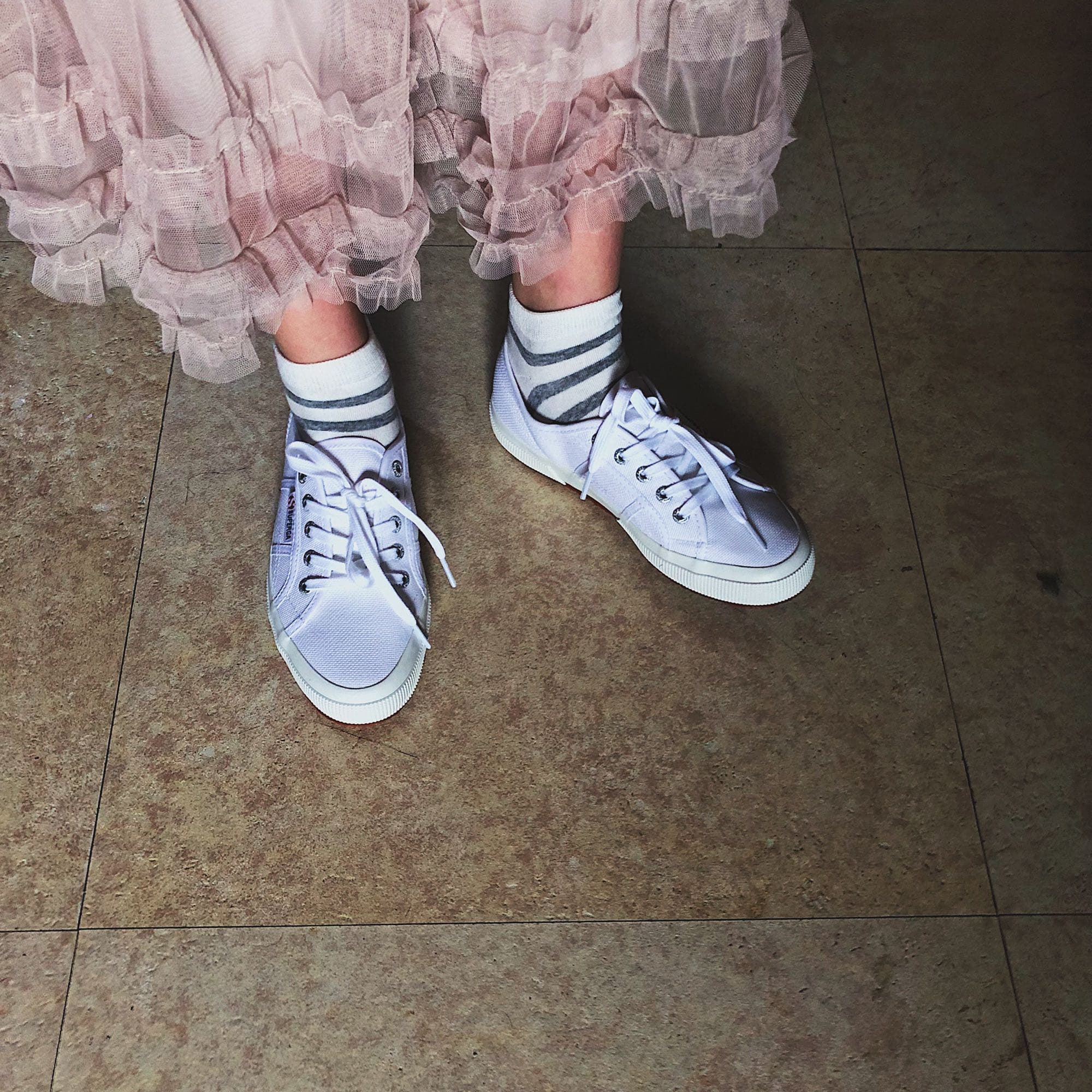 Motion-focused image of arched feet in sheer nylons, soft blur suggesting gentle movement, emphasis on curve and texture