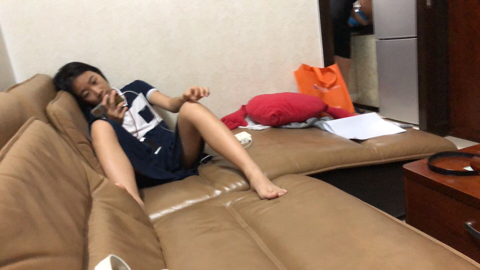 Two feet in different socks side by side, one bare heel, one nylon-clad toe catching warm lamplight