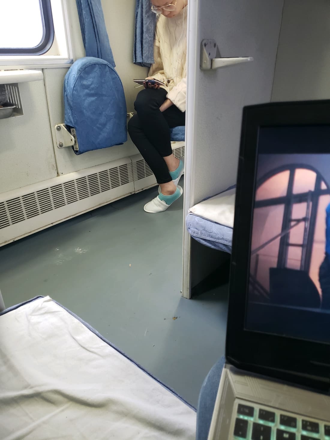 Rush-hour train scene with legs crossed, glimpses of stockings and exposed ankles among seated passengers