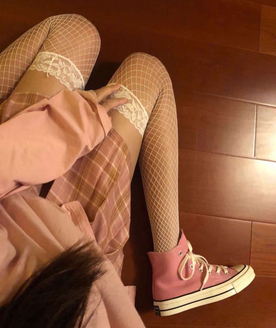 Close-up of bare feet slipping out of damp stockings, toes splayed and nylon clinging, heat giving skin a glossy sheen.