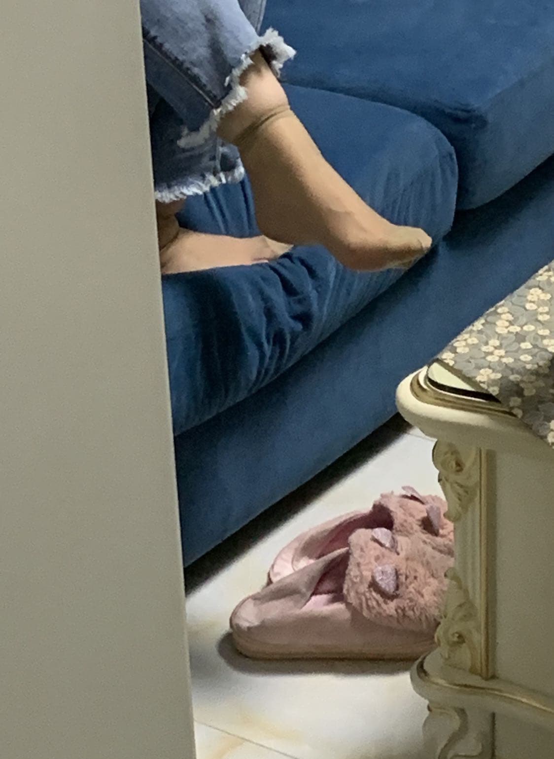 Forgotten pair of sheer stockings draped over a chair, faint creases and subtle scent suggested by soft lighting and close framing.