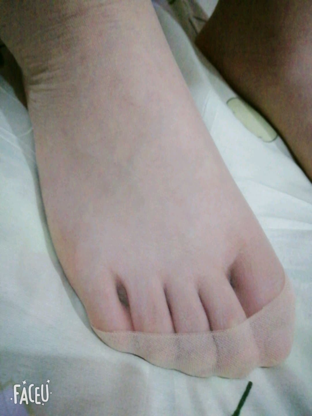 Nylon-clad toes curled in shadow