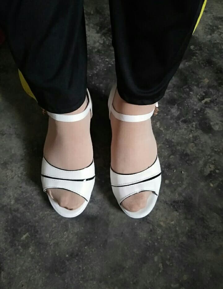 Wife’s feet resting on a couch, stockings rolled at ankle and one bare toe peeking from under a cozy sock