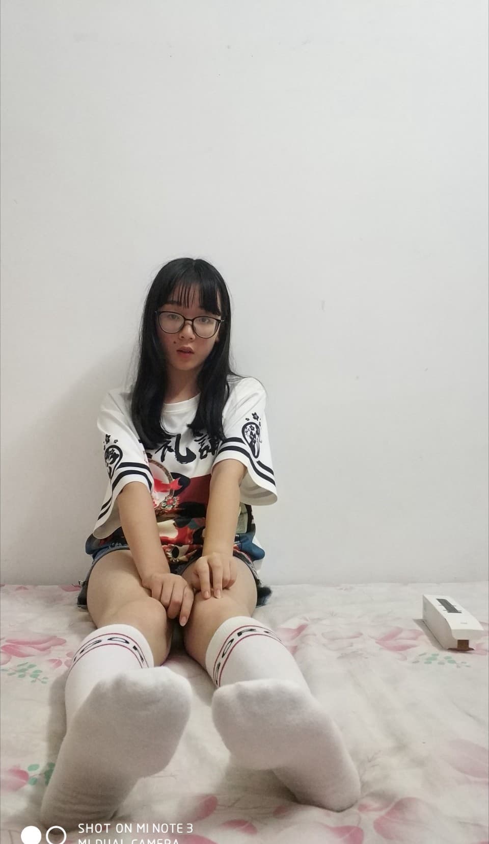 Reflective surface beneath stockinged feet creating doubled images as light skims silky fabric and arches.