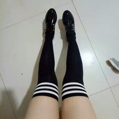 Feet clad in mixed hosiery and socks, toes tapping lightly and creating a playful, rhythmic visual cadence