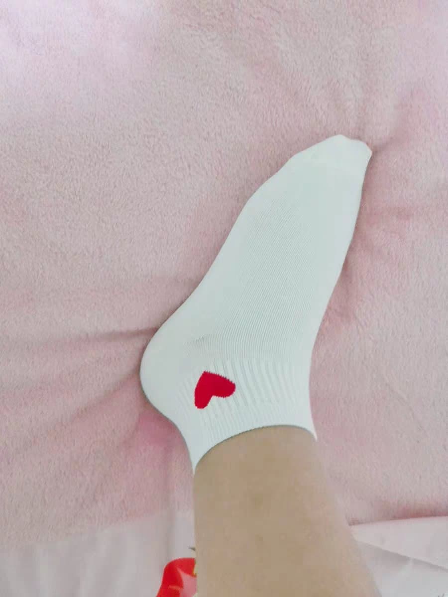 Shimmering nylon-clad legs crossed on a chaise, subtle sheen emphasizing the arch and gentle curve of the ankle.