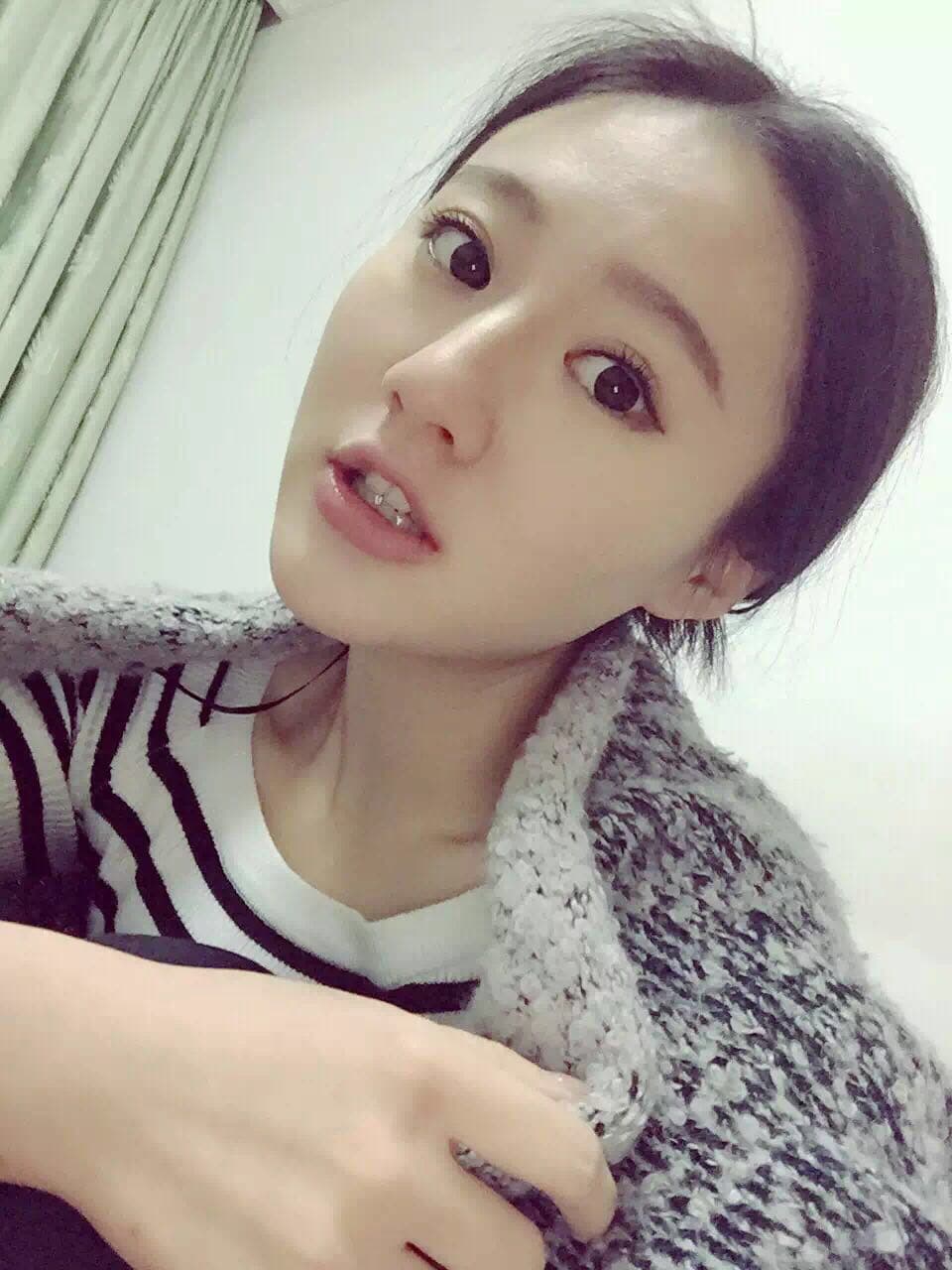 Confident woman posing with one stockinged foot forward and a worn cotton sock half-removed