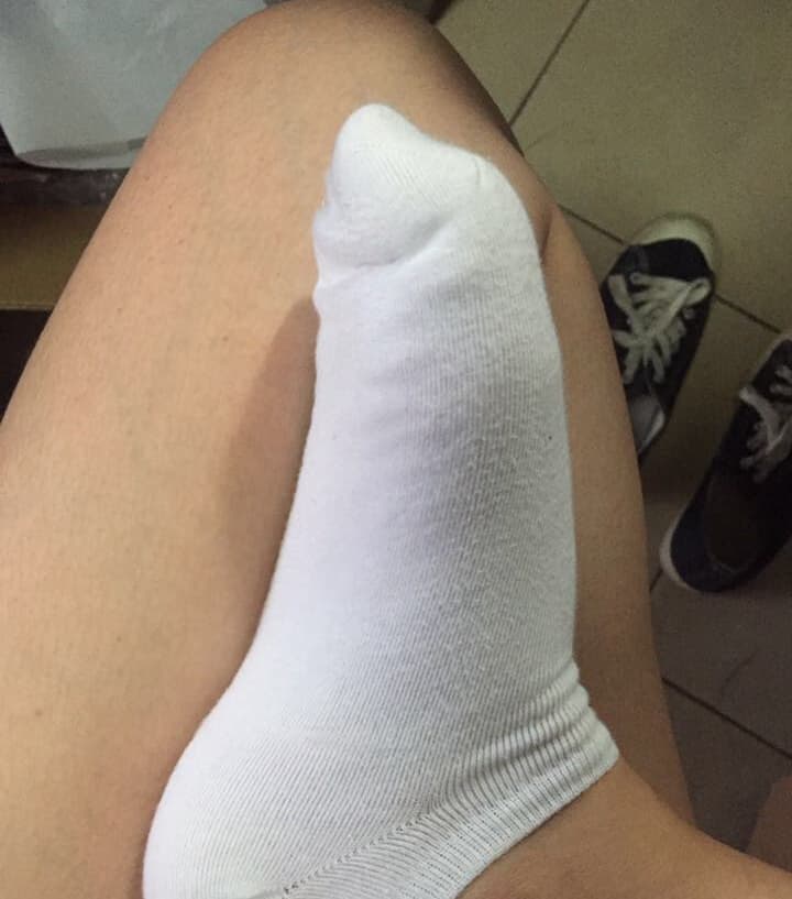 Low-angle shot showing bare arches and glossy stockings, toes softly splayed