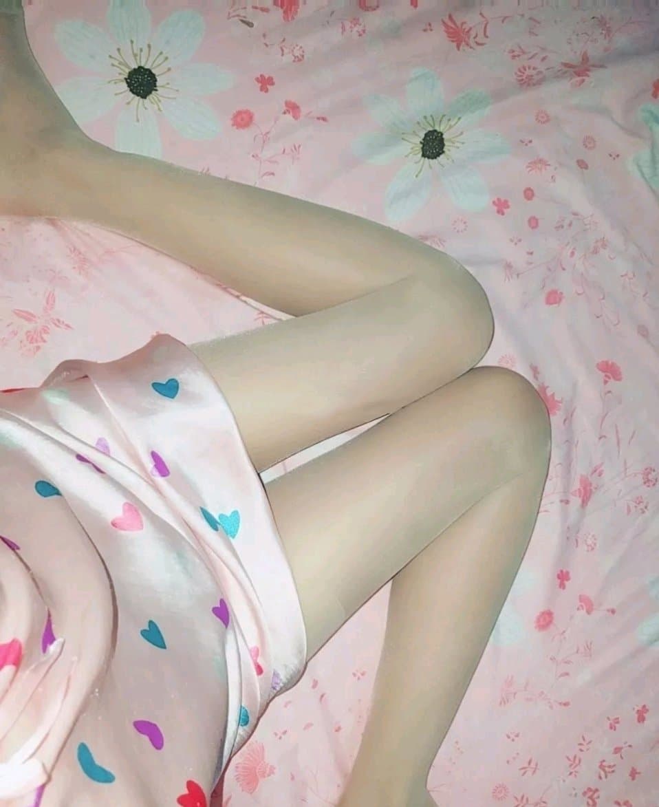 A barefoot silhouette on a sunlit floor, sheer socks discarded nearby, warm skin and gentle shadows