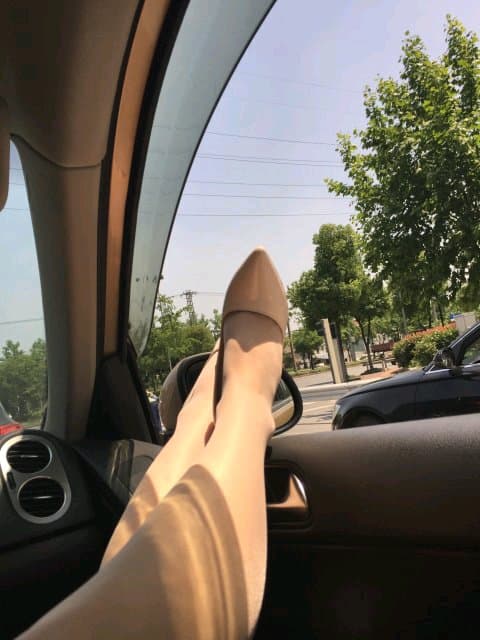 Sunlit stockinged leg in car