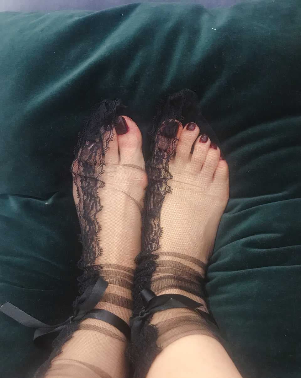 Leg in side-patterned stocking with decorative seam running down calf, hemline slightly lifted