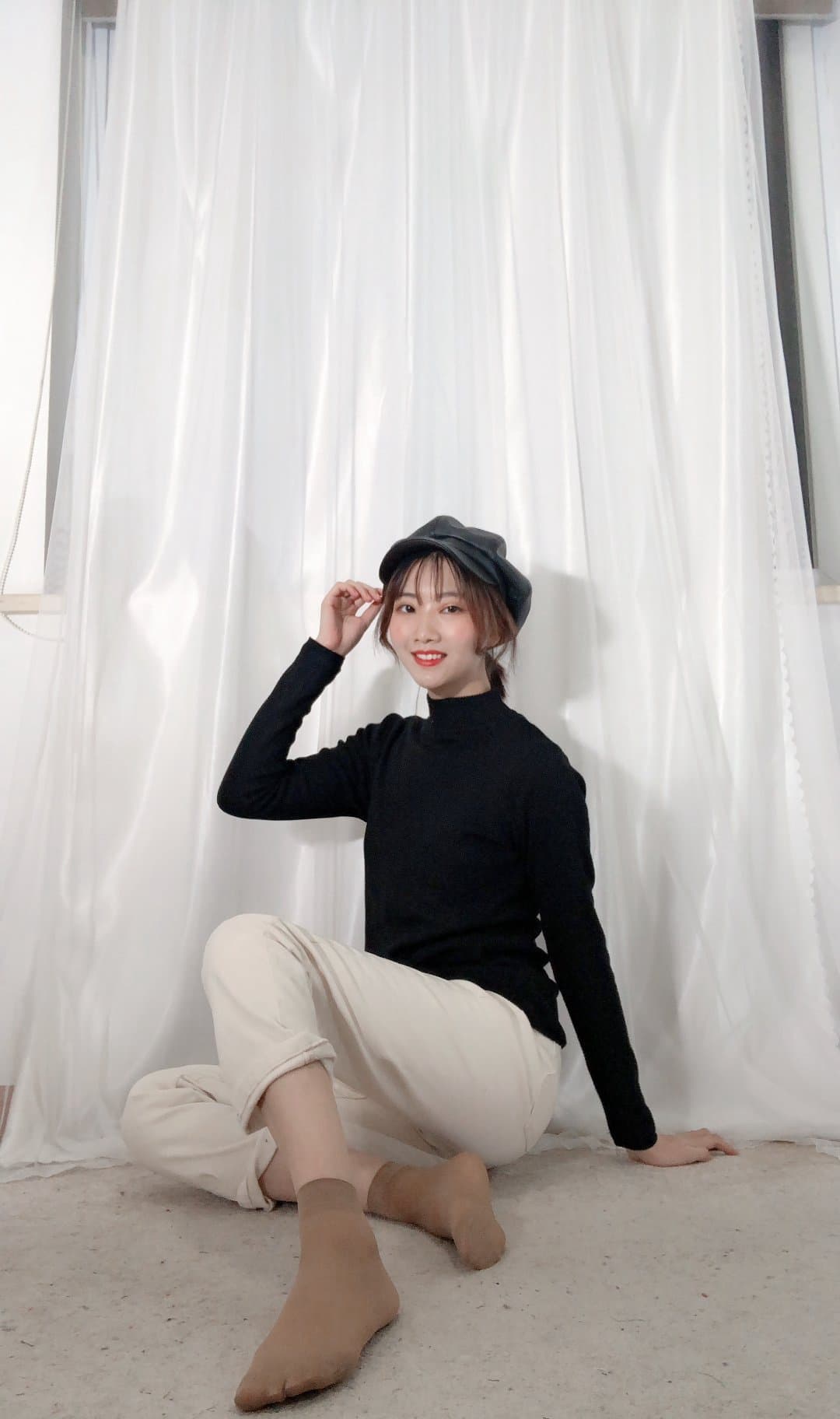 Artful photograph of her feet beside a small stuffed deer, cotton socks nearby and soft bokeh in the background.