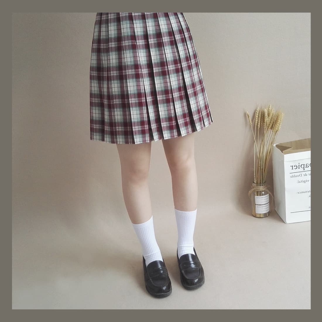 Stylized adult model in a uniform-inspired outfit, stockings and socks contrasted with bare ankles in tasteful composition