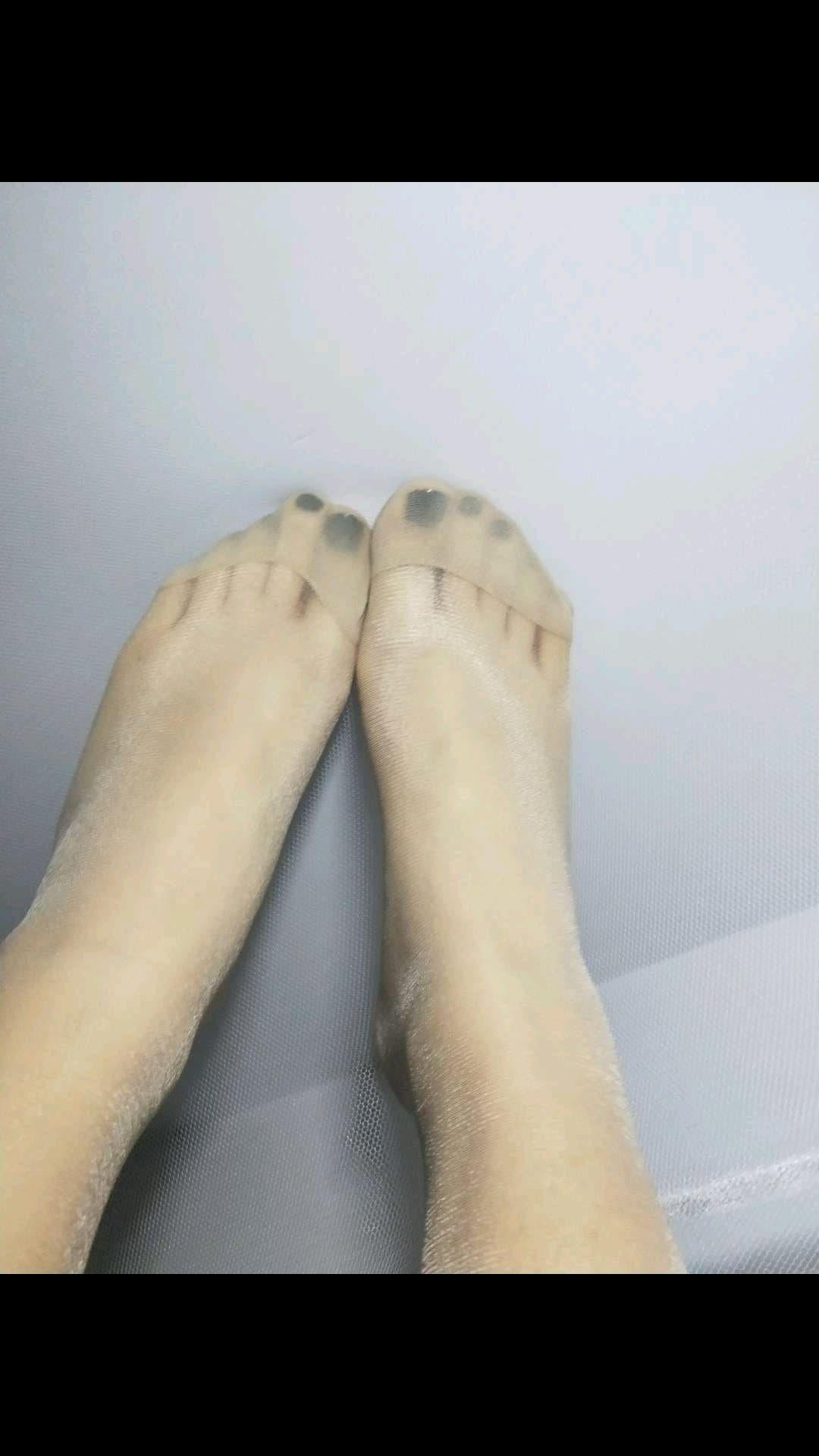 Portrait of adult model preparing for a private shoot, holding a pair of worn cotton socks and a set of flesh-toned stockings