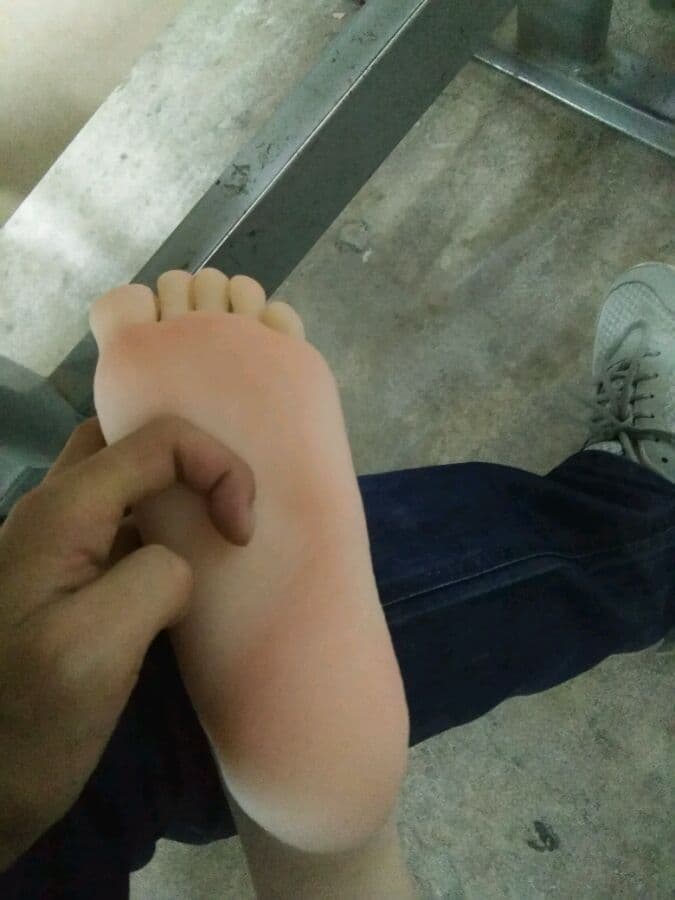High-resolution close-up of bare feet on hardwood, natural light emphasizing skin texture and toes