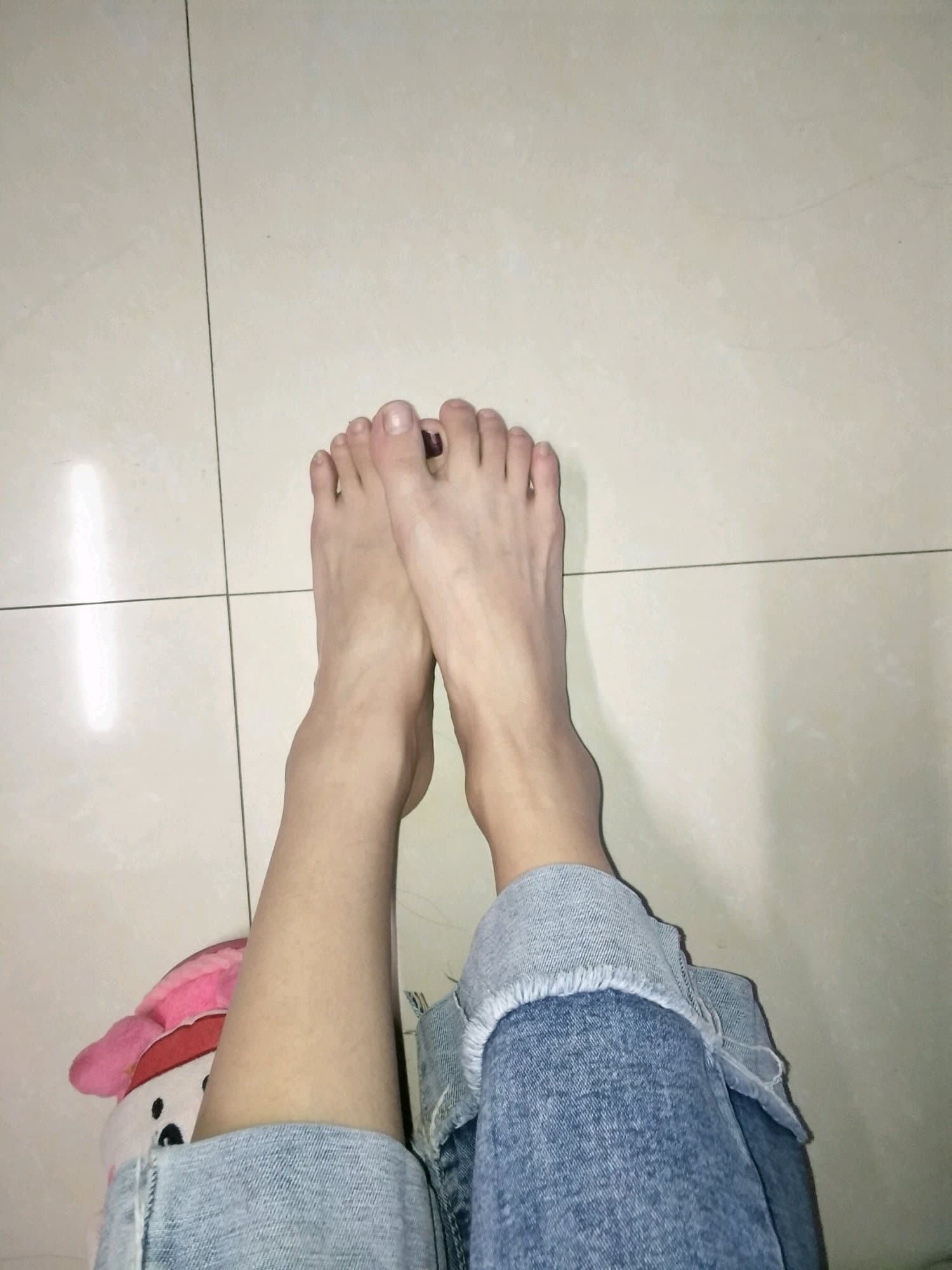 Model holding a verification sign while showing polished toes and sheer nylon stockings in a candid shot