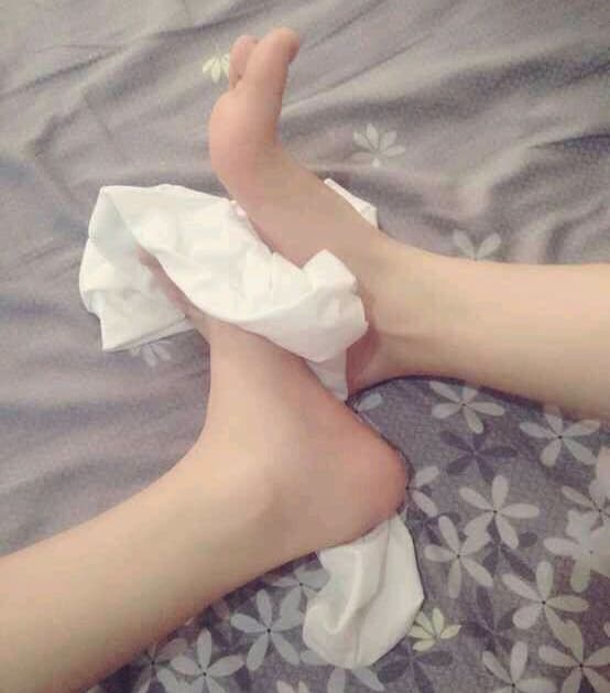 Feet in pastel lace socks with ruffled edges, toes visible and heels resting on a plush blanket