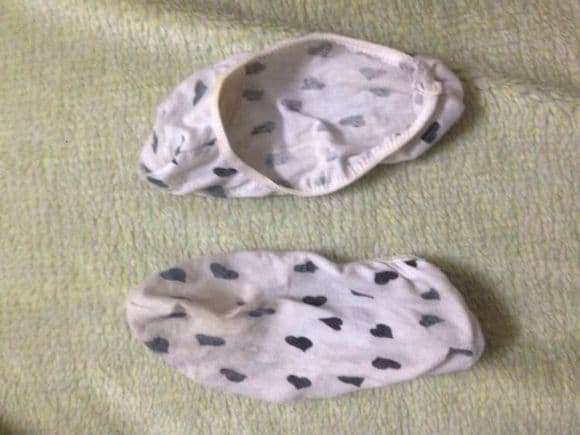 Worn boat sock half-pulled off a foot, stretched heel and fabric texture visible, toes beginning to show