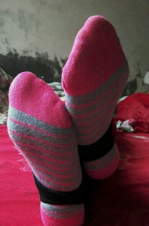 Bare foot wearing whimsical cartoon cotton sock, heel exposed and toes peeking from colorful fabric