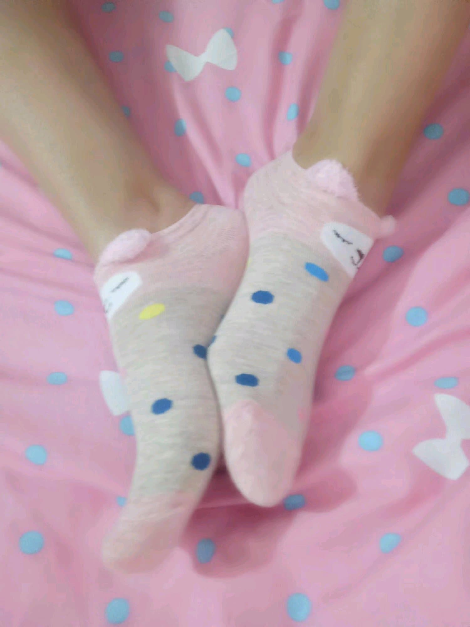 Close-up of bare foot arch resting against a glossy nylon stocking, toes gently flexed in warm light