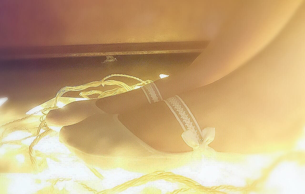 Tiny cotton socks hugging small feet, toes slightly exposed and arches softly curved in inviting light