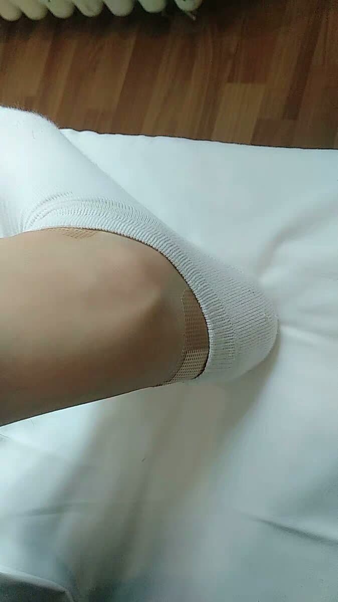 Intimate close-up of frayed stockings and exposed toes, threadbare details emphasizing texture and sensual wear