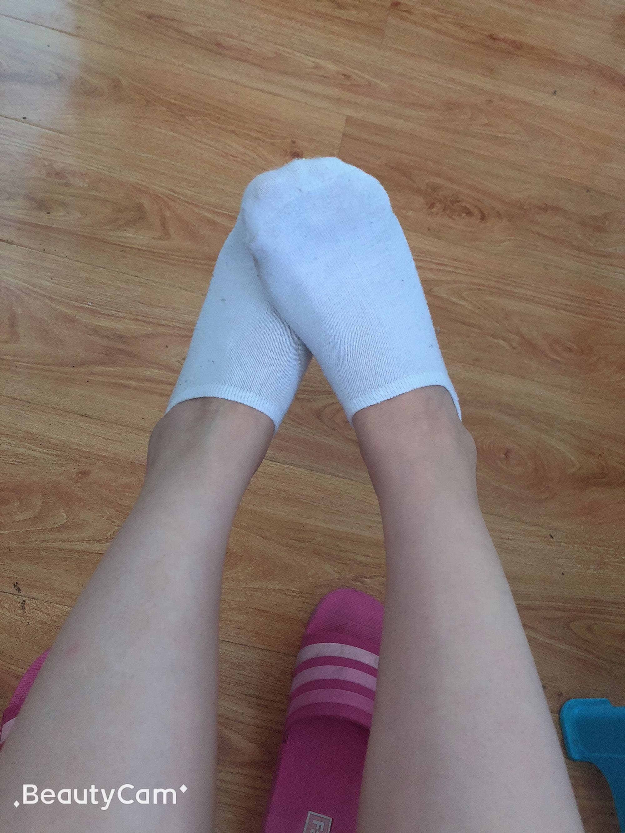 Close-up of white nylon stockings hugging toes and arch, soft light emphasizing silky texture and subtle sock crease