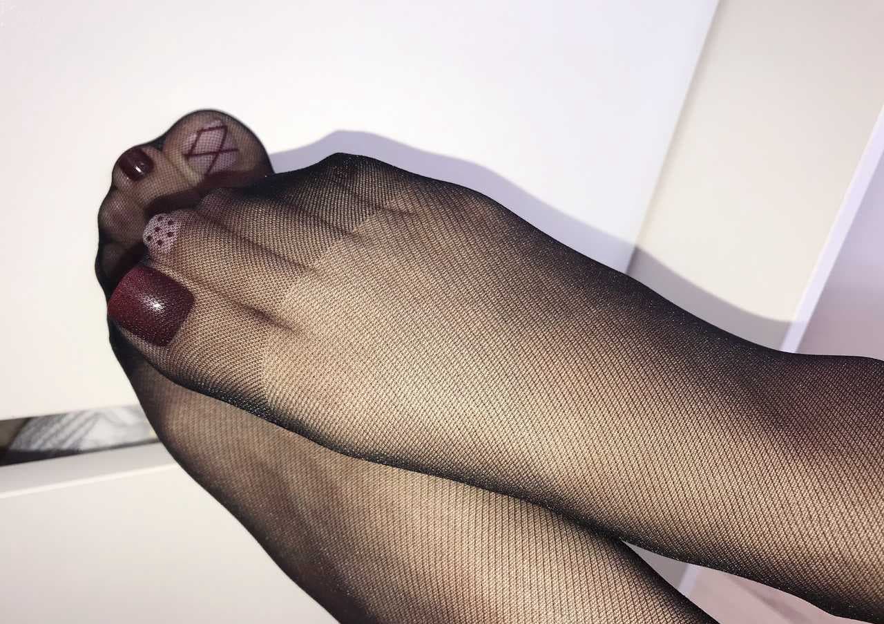 Polished toes through black stockings
