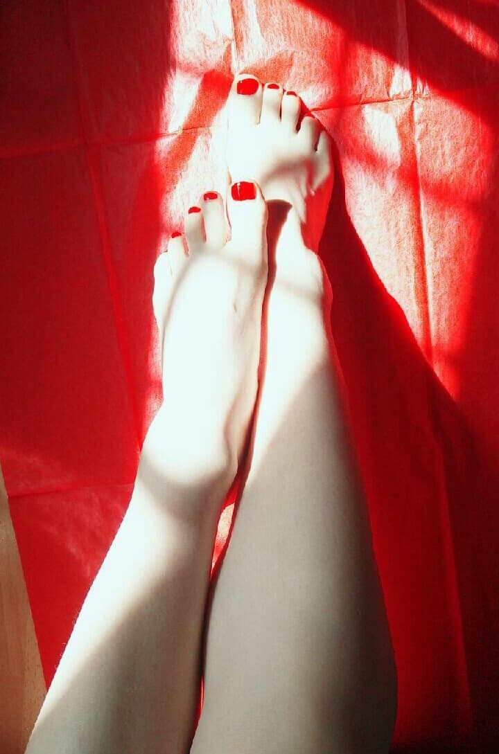 Sunlit bare feet on sofa